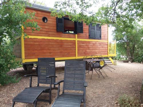 une petite maison assise sur une table et des chaises dans l'établissement Roulotte & Accès SPA Privatif, à Pauilhac