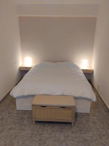 a bedroom with a bed with two lights on it at Céntrico y equipado apartamento in Sabiñánigo