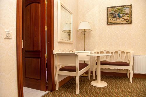 a room with a table and chairs and a mirror at Optima Collection Kamianets-Podilskyi in Kamianets-Podilskyi