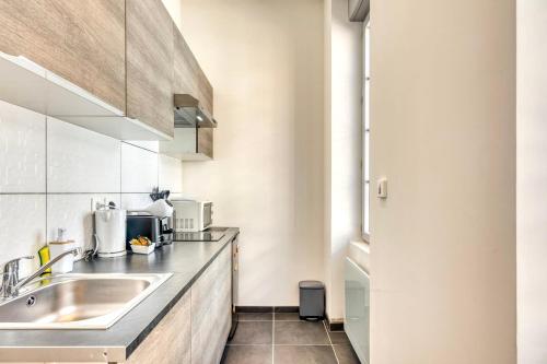 une cuisine avec un évier et un plan de travail dans l'établissement Le Martini - Clim mobile - studio au Brotteaux Métro B, à Lyon