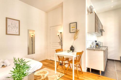un petit appartement avec une table et des chaises dans une pièce dans l'établissement Le Martini - Clim mobile - studio au Brotteaux Métro B, à Lyon