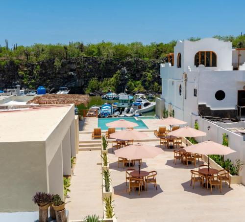 an outdoor patio with tables and chairs and umbrellas at El Barranco Galapagos in Puerto Ayora