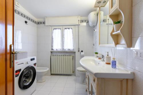Un baño con lavadora y lavabo. en Coastal Whisper - 9 min to Airport & 700m to Sea, en Focene