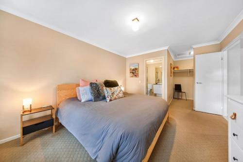 a bedroom with a large bed with a nightstand and a bed sidx sidx sidx at Ocean Grove retreat in Ocean Grove