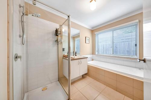 a bathroom with a shower and a tub and a sink at Ocean Grove retreat in Ocean Grove