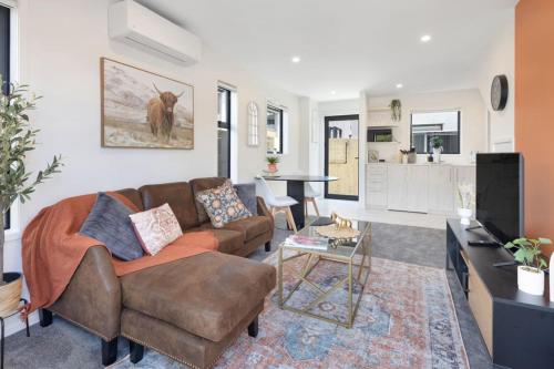a living room with a couch and a kitchen at Radiant Spot on Biddle Crescent in Lower Hutt