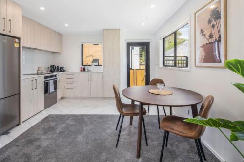 a kitchen with a table and chairs in a room at The Grove Hideaway in Lower Hutt