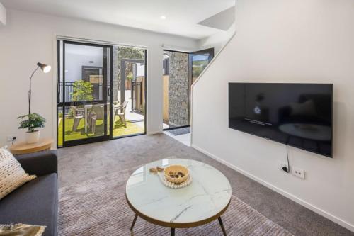 a living room with a table and a tv at Ariki Artistry Lower Hutt 2BR Sanctuary in Lower Hutt