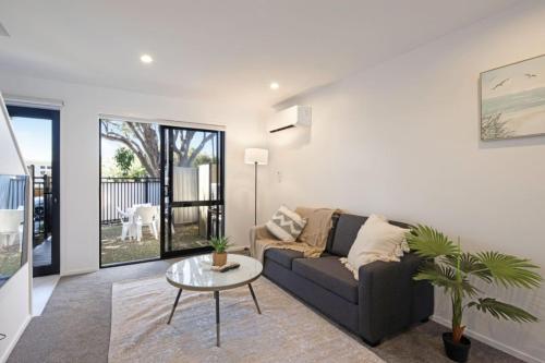 a living room with a couch and a table at Ariki Serenade House 2BR Peaceful Stay in Lower Hutt