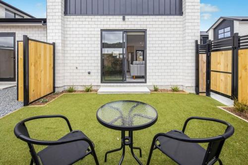 a patio with two chairs and a table in the grass at Oliver Oasis Wellington 2BR Retreat in Upper Hutt