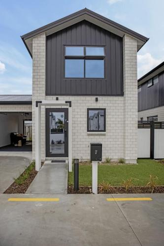 a house with a black and white at Hillview Hideaway 2-BR Serenity in Upper Hutt