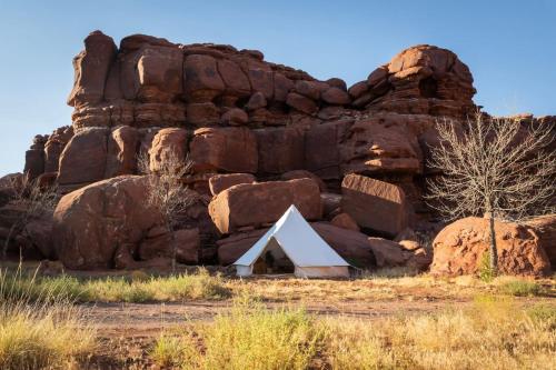a rock formation with a triangle in front of it at Glamping Queen Tent At Private Riverside Ranch in Moab