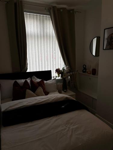a bedroom with a large bed with a window at Divine Place in Bloxwich
