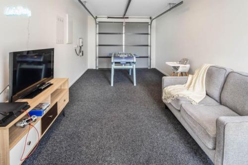 a living room with a couch and a tv at Sunny 2 BR Oasis in Trentham in Upper Hutt