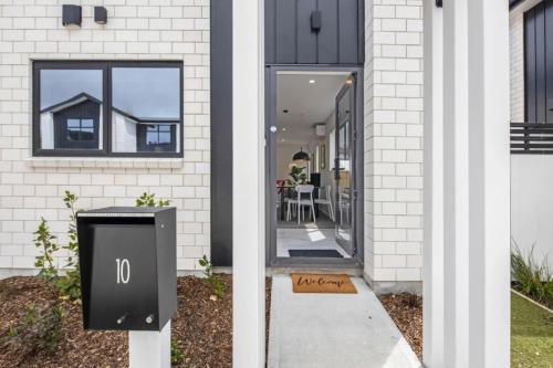 a house with a trash can in front of a door at Sunny 2 BR Oasis in Trentham in Upper Hutt