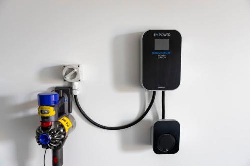 a computer hooked up to a wall with a charger at Homely Haven in Trentham - 2BR in Upper Hutt