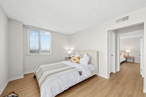 a white bedroom with a large bed and a window at The Lilas-Ocean view Stay high floor Pool Parking in Los Angeles