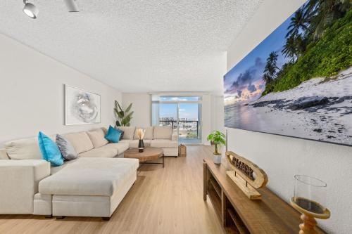 a living room with white furniture and a large painting on the wall at The Lilas-Ocean view Stay high floor Pool Parking in Los Angeles