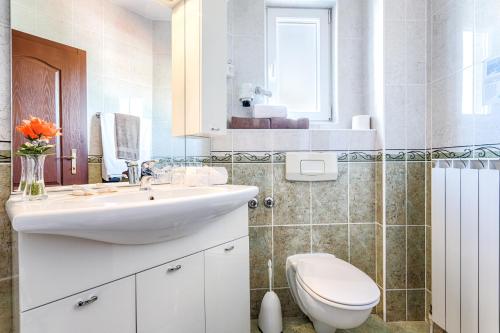 a bathroom with a white sink and a toilet at Hotel Viktorija in Seget Vranjica
