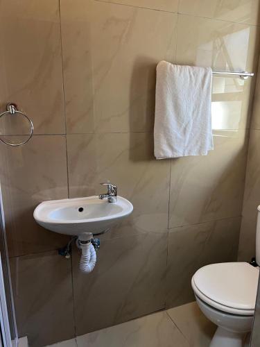 a bathroom with a sink and a toilet at Our Home Guest House in Bellville