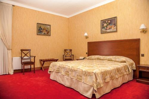 a hotel room with a bed and a red carpet at Optima Collection Kamianets-Podilskyi in Kamianets-Podilskyi