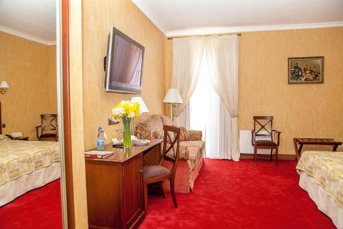a hotel room with a desk with flowers on it at Optima Collection Kamianets-Podilskyi in Kamianets-Podilskyi