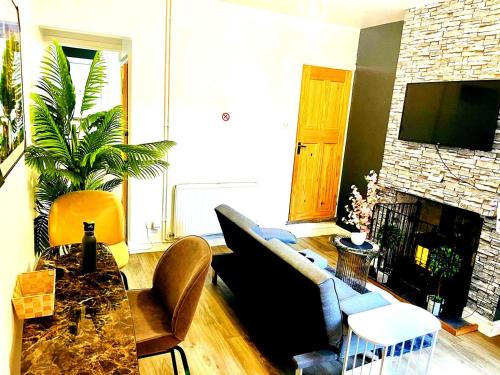 a living room with a couch and a fireplace at Cozy and stylish 2 bedroom home in Leicester
