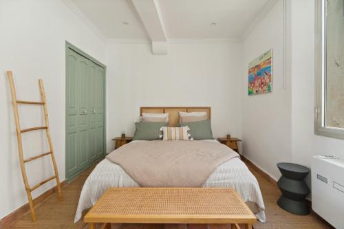 サントロペにあるApartment with SEA VIEW in St Tropez - La Poncheのベッドと木製のテーブルのある寝室