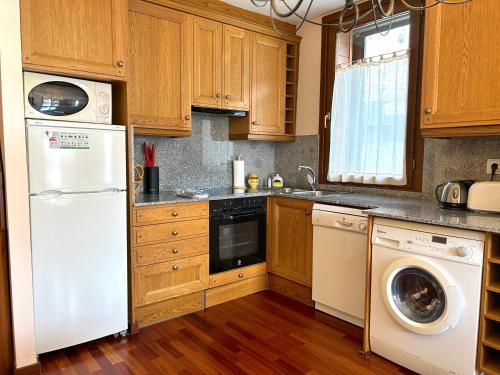 a kitchen with a white refrigerator and a dishwasher at Apartament amb una terrassa única by RURAL D'ANEU in Esterri d'Àneu