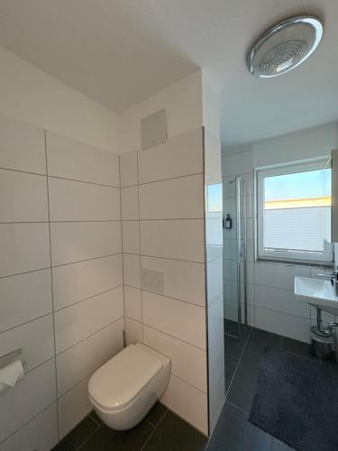 a bathroom with a toilet and a sink at Modernes Serviced Apartment - FeWo Penthouse View in Nördlingen