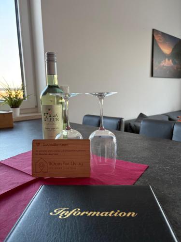 a bottle of wine and two glasses on a table at Modernes Serviced Apartment - FeWo Penthouse View in Nördlingen
