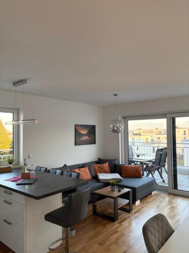 a living room with a couch and a table at Modernes Serviced Apartment - FeWo Penthouse View in Nördlingen