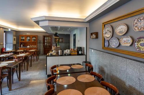 un ristorante con tavoli, sedie e piatti sul muro di Hotel Vitória a Coimbra