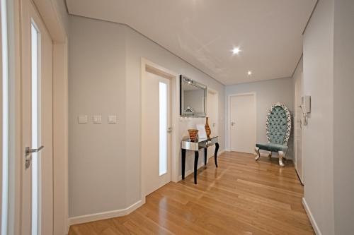 a hallway with a table and a chair in a room at Urbanização Casas Do Lago, Serra de Carnaxide in Amadora