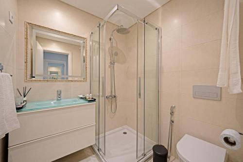 a bathroom with a glass shower and a sink at Urbanização Casas Do Lago, Serra de Carnaxide in Amadora