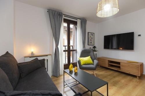 Una sala de estar con un sofá y un televisor. en Casa Real by BeValle, en Escarrilla