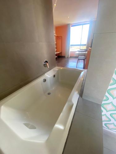a large white bath tub sitting in a room at G Hotel by Gaya Group in Santa Cruz de la Sierra