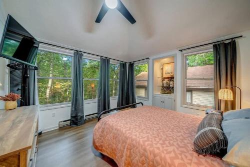 a bedroom with a bed and large windows at Secluded Retreat w Hot Tub, FirePit & Pool Access in Hedgesville