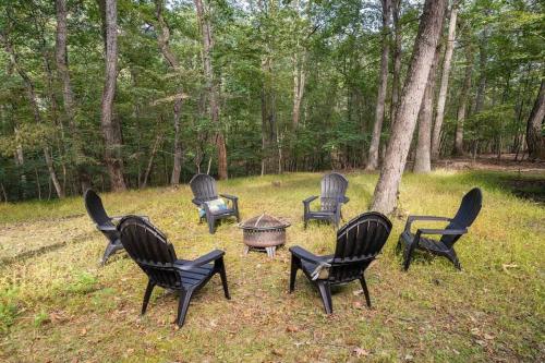 a group of chairs sitting around a table in the grass at Secluded Retreat w Hot Tub, FirePit & Pool Access in Hedgesville