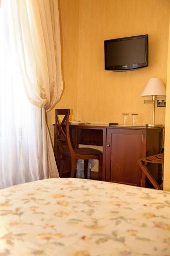 a hotel room with a desk and a television at Optima Collection Kamianets-Podilskyi in Kamianets-Podilskyi