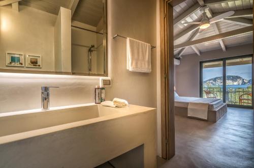 a bathroom with a tub and a bedroom with a view at Lithalona Villas & Houses in Marathias