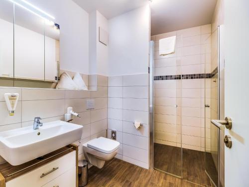 a bathroom with a toilet sink and a shower at Luxuriöse Ferienwohnung am Störmthaler See in Großpösna