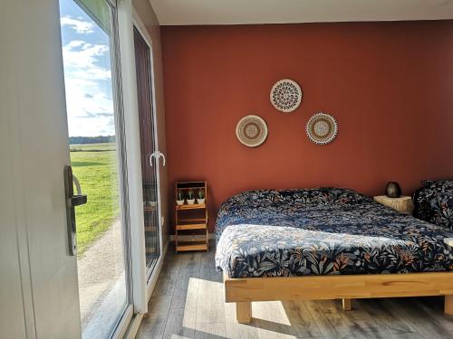 a bedroom with a bed and a large window at Nature et bien- être in Sauvigney-lès-Pesmes