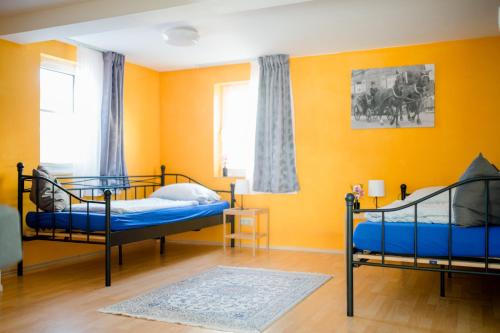 two beds in a room with yellow walls at Ferienhaus Petri Limburg in Limburg an der Lahn