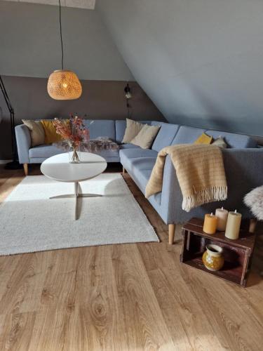 a living room with a blue couch and a table at Stædets lejlighed in Bøvlingbjerg