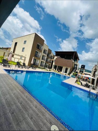 a large blue swimming pool in front of a building at AIDEN HOMES AND APARTMENTS HOTEl in Koforidua