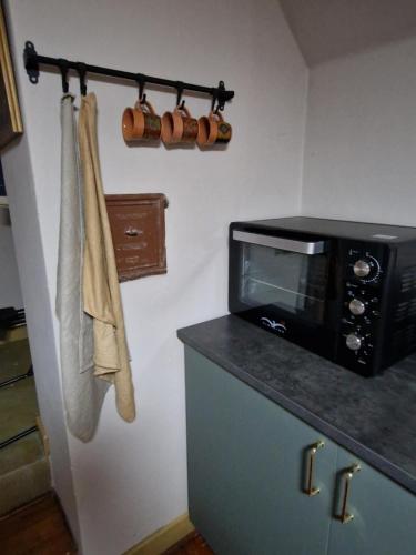 a kitchen with a microwave and a counter with towels at Stædets lejlighed in Bøvlingbjerg