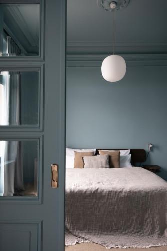 a bedroom with a bed with a mirror and a lamp at stilwerk Strandhotel Blankenese in Hamburg