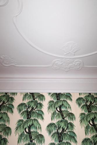 a white ceiling with a mural of palm trees at stilwerk Strandhotel Blankenese in Hamburg