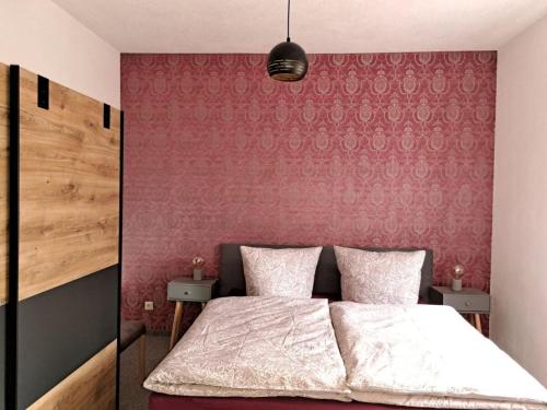 a bedroom with a bed and a red wall at Holiday Apartment FeWo III in Reinhardtsdorf